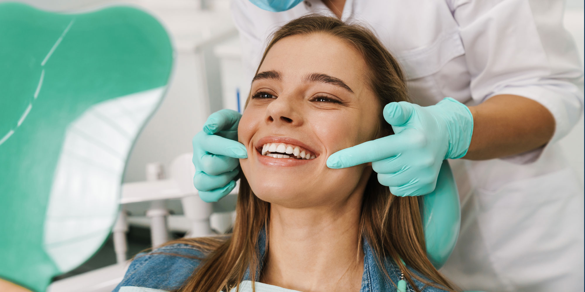 cosmetic dental patient afterteethwhitening smiling into mirror